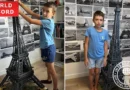 8-year-old holding completed Eiffel Tower model