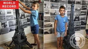 8-year-old holding completed Eiffel Tower model