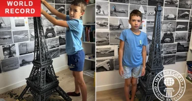 8-year-old holding completed Eiffel Tower model