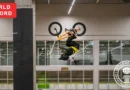 Young BMX athlete completing a double backflip with a stable landing