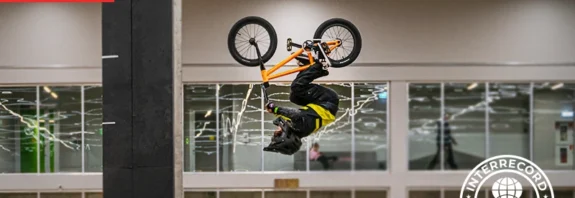 Young BMX athlete completing a double backflip with a stable landing